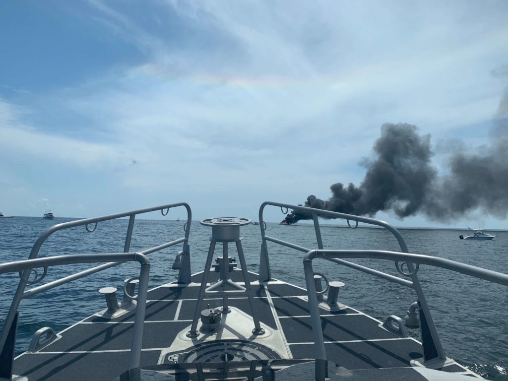 Smoke from a charter vessel fire is seen off the bow of a 45-foot rescue boat dispatched from Station Pensacola near Perdido Pass, Alabama, July 27, 2019. The crew worked with the local fire department as well as good samaritan mariners to put out the fire. 