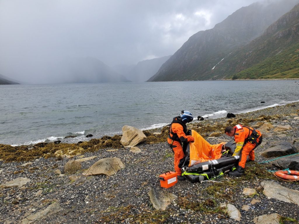Coast Guard aircrew recover a life raft in Three Saints Bay