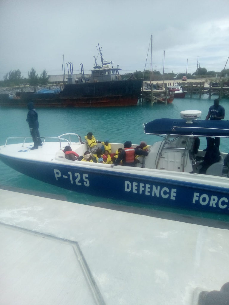 The Turks and Caicos Police Force transfers search and rescue survivors ashore, Dec. 21, 2019 after working with the Coast Guard and Royal Bahamas Defence Force to rescue them. The Coast Guard Cutter Seneca (WMEC-906) crew and a Her Majesty's Bahamian Ship crew arrived on scene and embarked the 187 people between the two ships after a Coast Guard Air Station Clearwater MH-60 Jayhawk helicopter crew, forward deployed to the Great Inagua, Bahamas, spotted a 30-foot vessel carrying 187 people. 