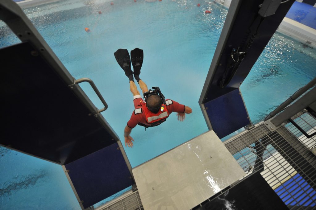 Airman William Carvallo, an aviation survival technician in training, conducts a free fall deployment into a pool during training at the Aviation Technical Training Center in Elizabeth City, N.C. 