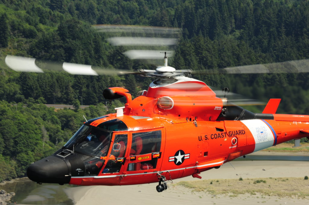 MH-65 Dolphin helicopter from Air Station Humboldt Bay transits over the Pacific Ocean to participate in cliff rescue training. Coast Guard fishing Elly