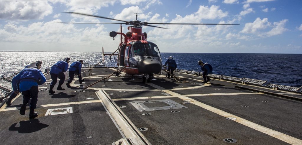 The crew aboard the Coast Guard Cutter Escanaba prepares to untie an MH-65 Dolphin helicopter from Air Station Borinquen, Puerto Rico. Earthquake Puerto Rico