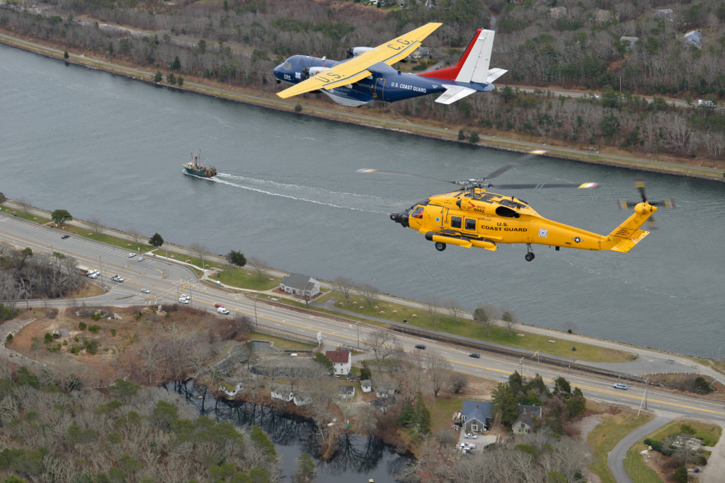 The centennial HC-144 Ocean Sentry airplane and MH-60 Jayhawk helicopter fly Cape Cod Canal, Monday, Dec. 16, 2019. Coast Guard Air Station Cape Cod will celebrate 104 years of aviation in Massachusetts and 50 years on Cape Cod.