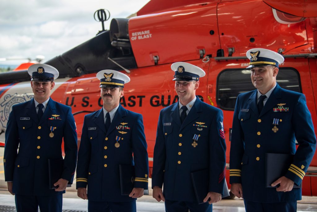 Coast Guard Air Station Humboldt Bay crew members Petty Officer 3rd Class Tyler Cook, an aviation maintenance technician, Lt.j.g. Adam Ownbey, a MH-65 Dolphin helicopter pilot, Petty Officer 1st Class Graham McGinnis, an aviation survival technician, Cmdr. Derek Schramel, a MH-65 Dolphin helicopter pilot, stand for a photo Aug. 6, 2020, in Humboldt Bay, California. 