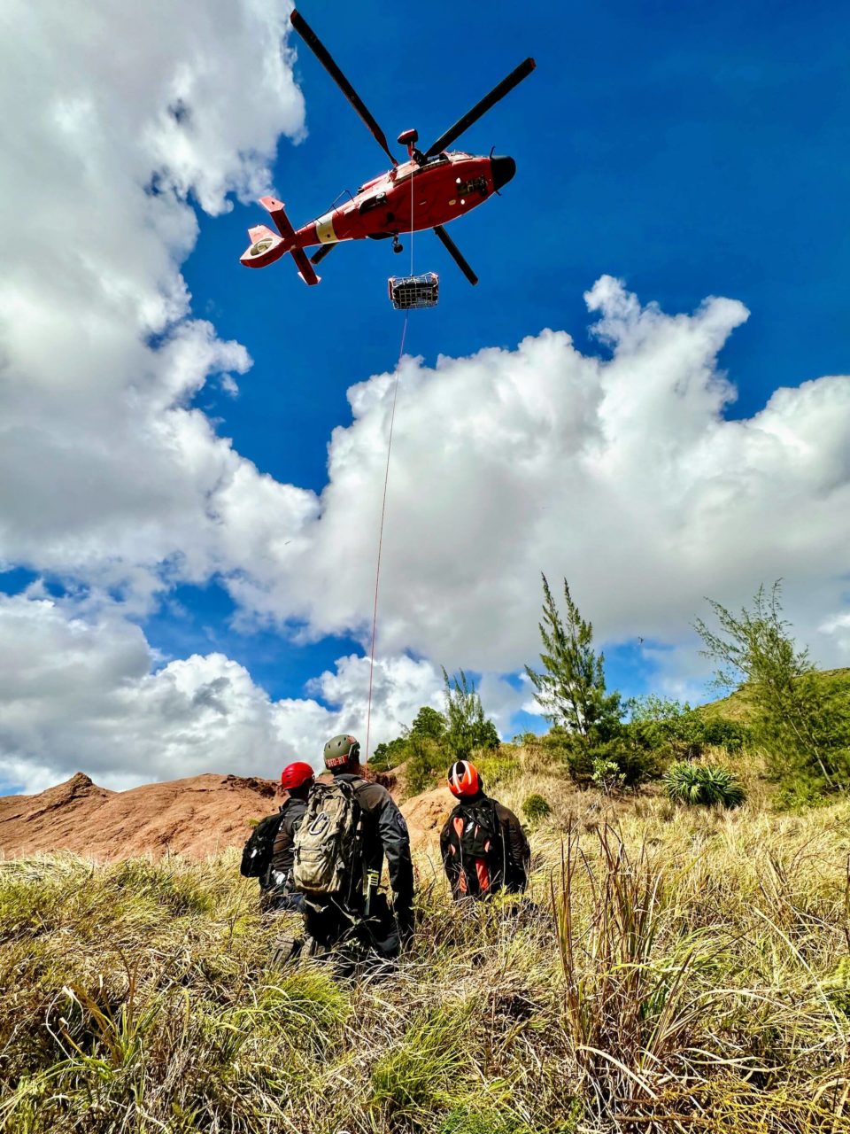 Guam Fire Department and U.S. Coast Guard members conduct rescue hoist training at Sella Bay Overlook in Guam on March 8, 2023. The exercise allowed the crews to assess the procedures each agency is familiar with and practice hoisting a rescue basket and a rescue swimmer from the aircraft. For the aircrew, it also served as an area familiarization to better understand the terrain and winds common on Guam's southwest coast. (U.S. Coast Guard photo by Petty Officer 2nd Class Ethan Bray)